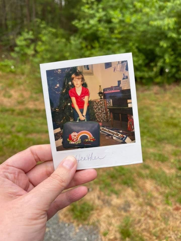 Young Heather with her first suitcase — where the travel bug began