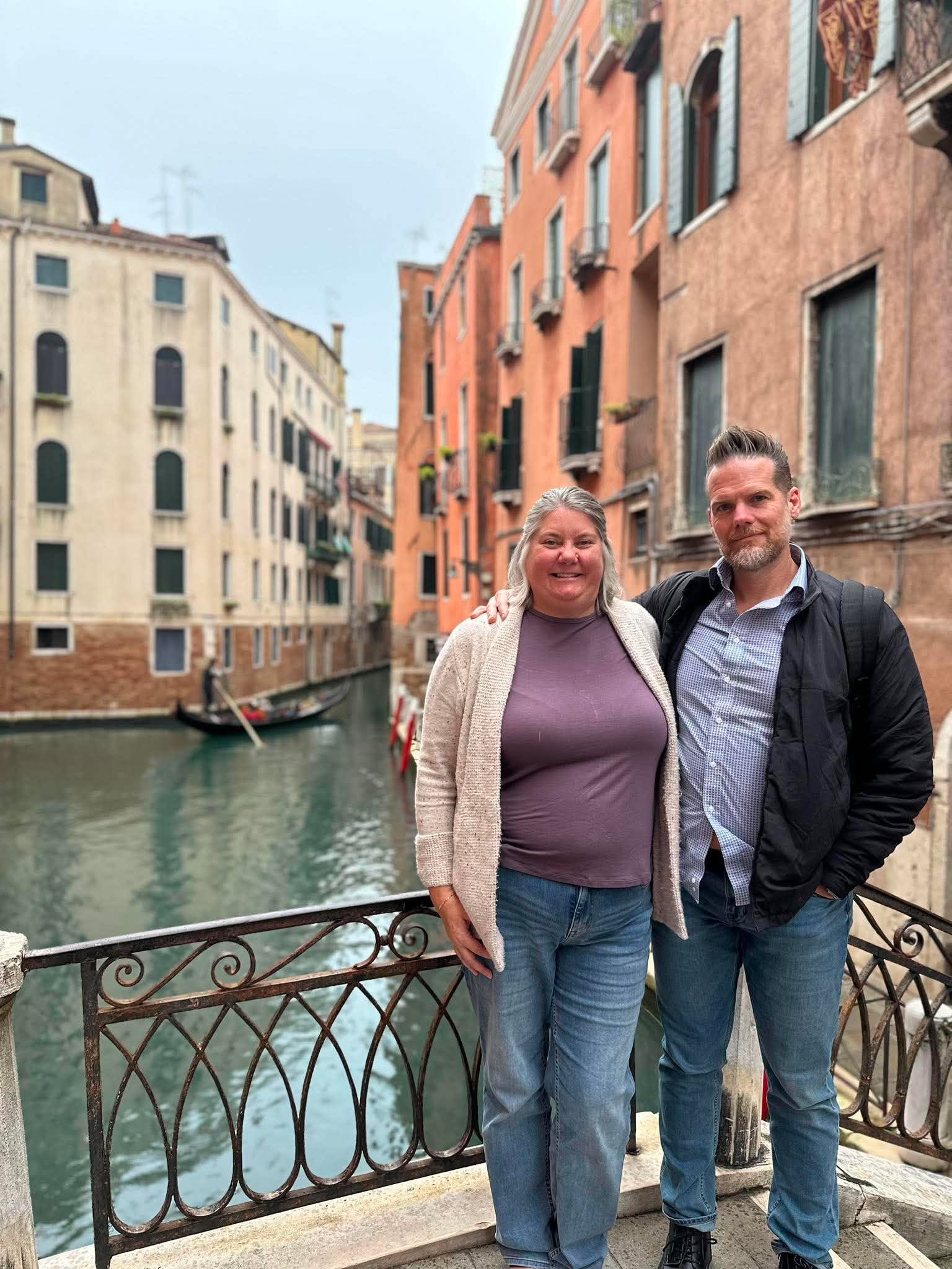 Heather and her husband on a bridge overlooking a Venice canal